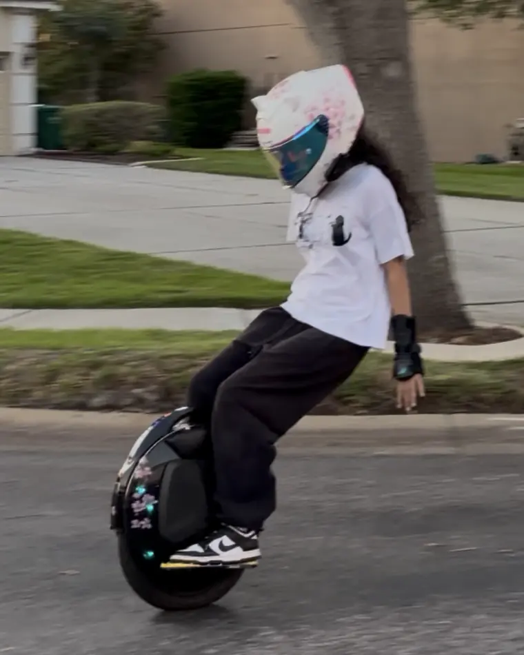 Keiko riding down the street, leaning back