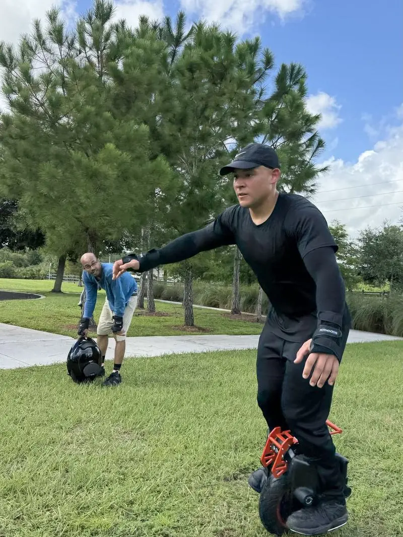 A rider out on the grass with another rider behind